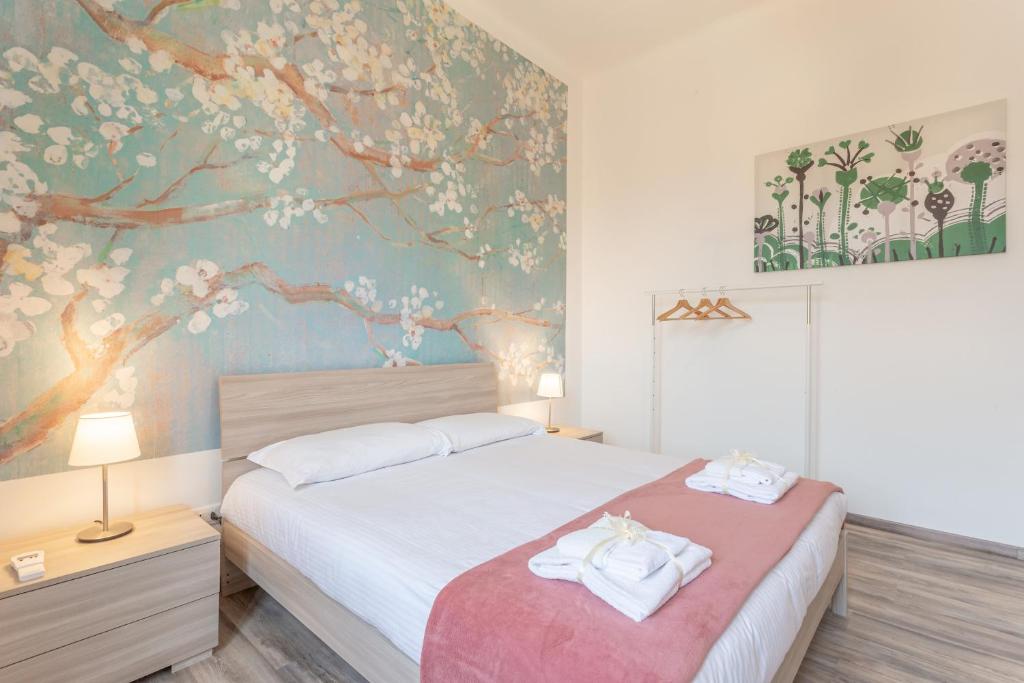 um quarto com uma cama e uma parede floral em Verdi 185 em Livorno