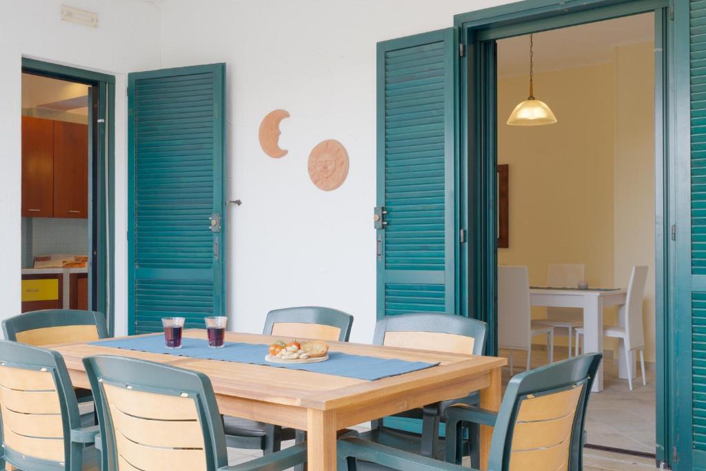 a dining room with a wooden table and chairs at Blue Sea - Villa Aquilone by Wonderful Italy in Ostuni