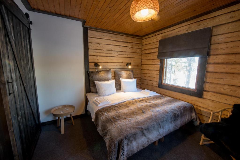 a bedroom with a bed in a wooden cabin at Hotel Krapi in Tuusula