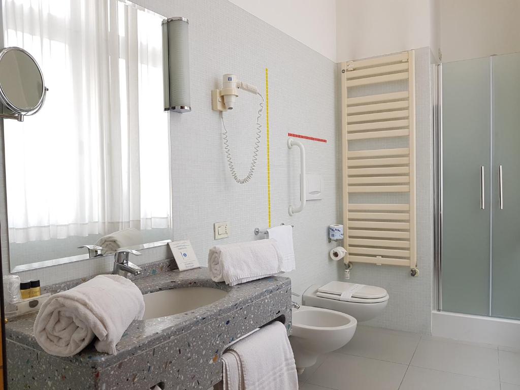 Hotel Grand'Italia في بادوفا: حمام مع حوض ومرحاض