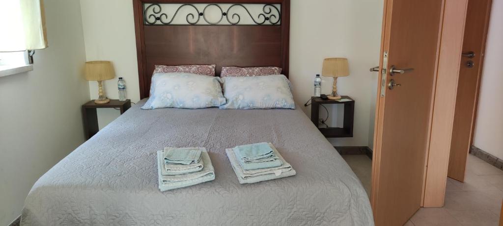 a bedroom with a large bed with towels on it at Beco do Patalugo in Salir de Matos