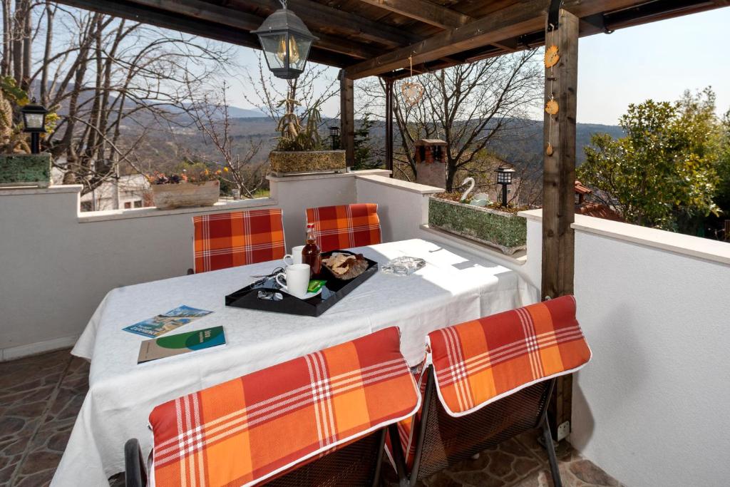 einen Tisch mit Stühlen auf einem Balkon mit Aussicht in der Unterkunft Apartment Pod Lipom in Roč