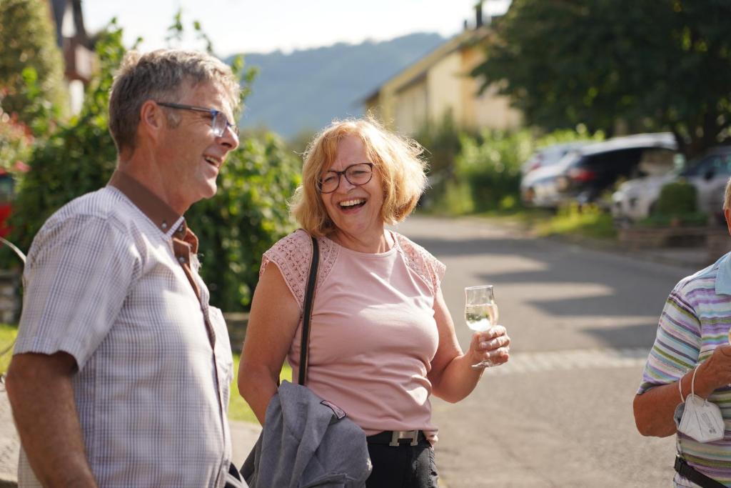 Ein älterer Mann und eine Frau mit einem Glas Wein. in der Unterkunft Weingut Hirschen Enkircherweg in Burg (an der Mosel)