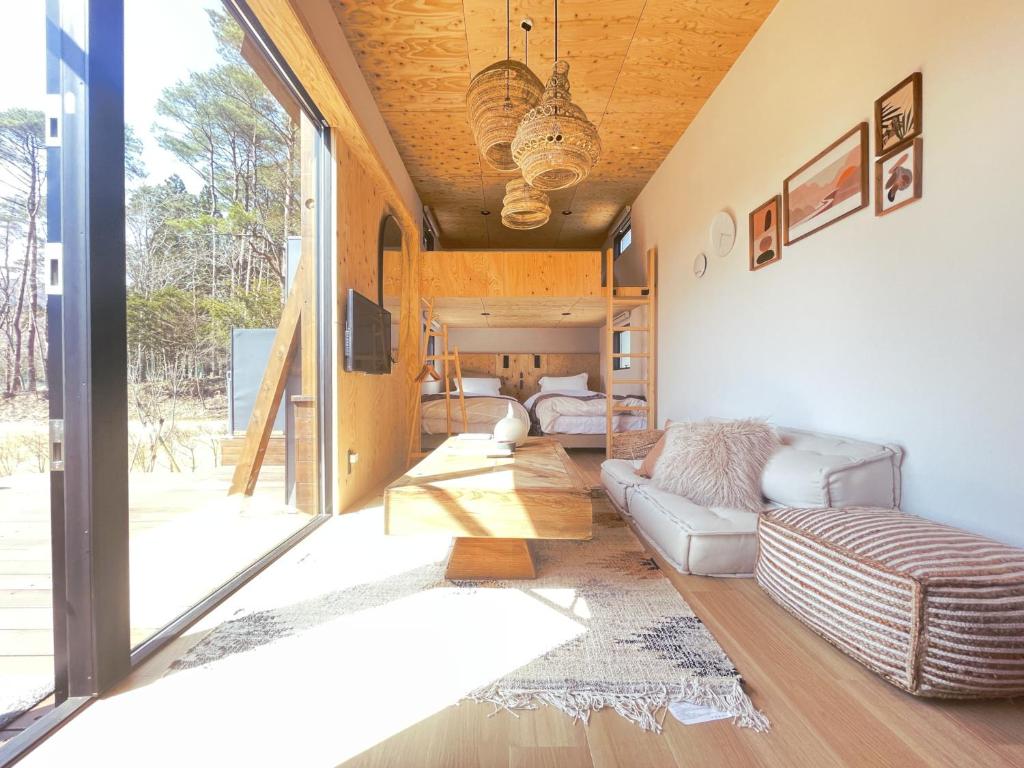 ein Wohnzimmer mit einem Sofa und einem TV in der Unterkunft GLANSTELLA CABIN Fujiyamanakako in Yamanakako