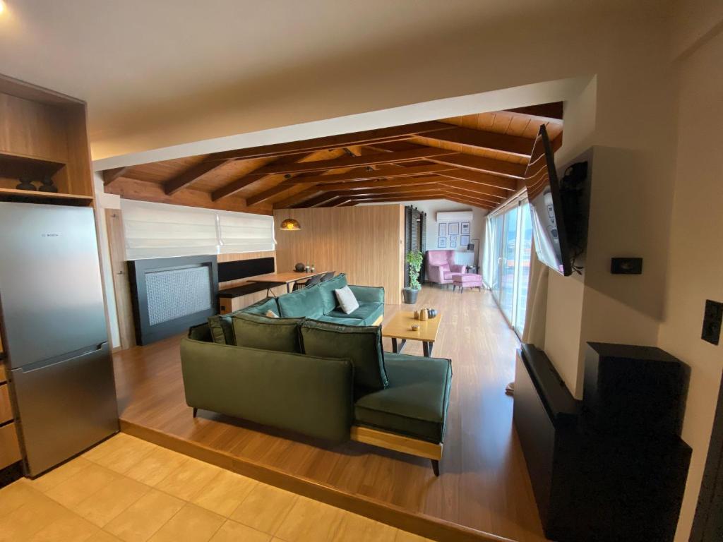 uma sala de estar com um sofá verde e uma mesa em Apollon Loft em Chalkida