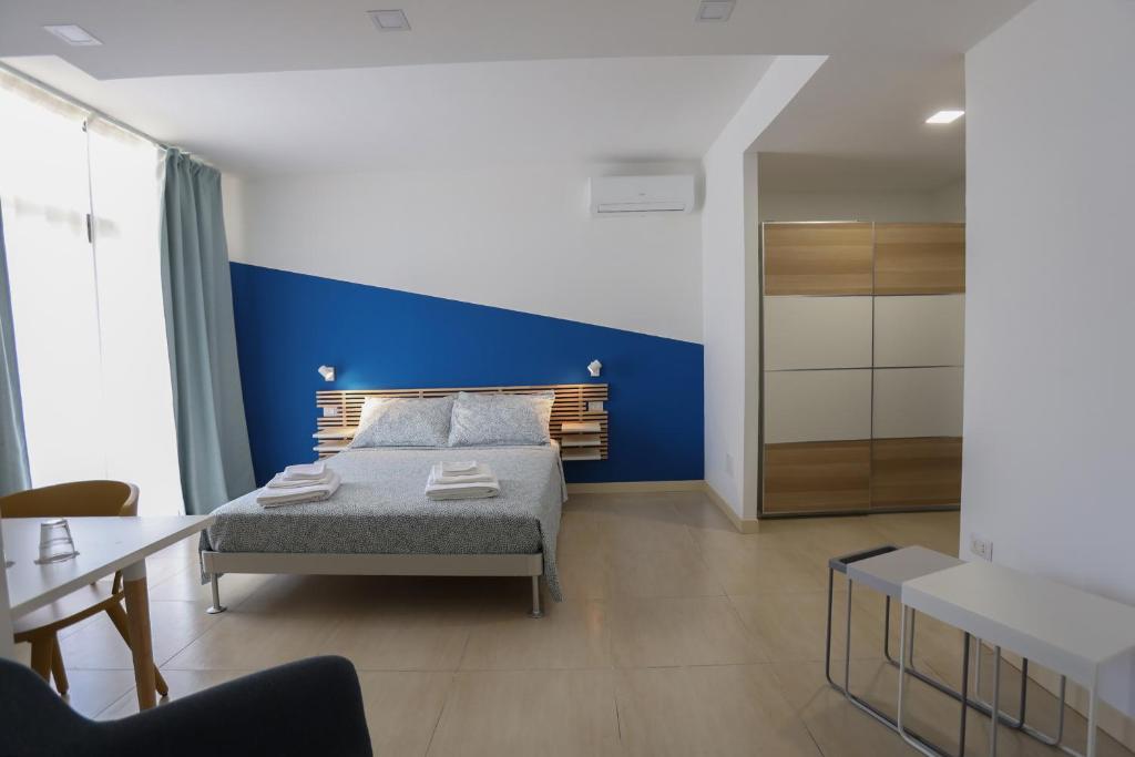 - une chambre avec un lit et un mur bleu dans l'établissement Affittacamere Aria Di Mare, à Paestum