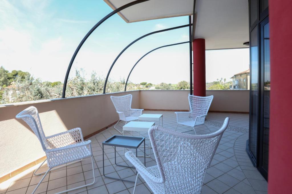 balkon z krzesłami i stołami w budynku w obiekcie Affittacamere Aria Di Mare w mieście Paestum