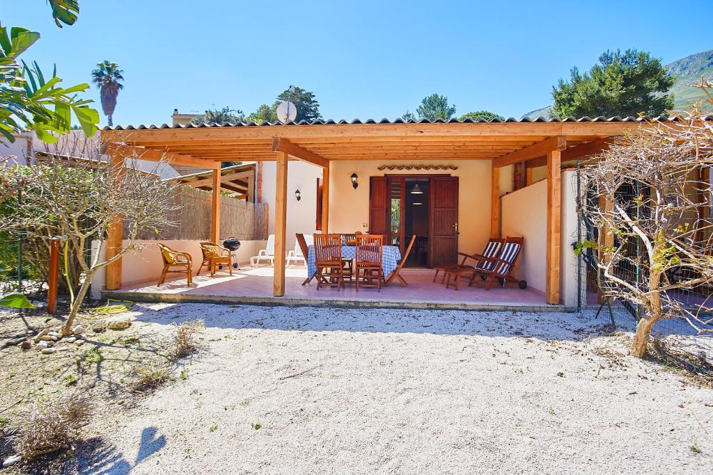 ein Haus mit einer Terrasse mit einem Tisch und Stühlen in der Unterkunft Case di Calamazzo in Scopello
