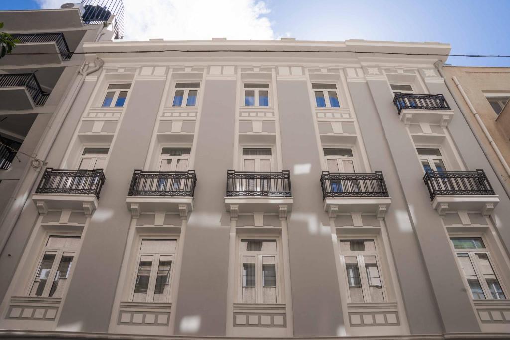 a tall building with balconies on the side of it at Paleo Suites in Athens