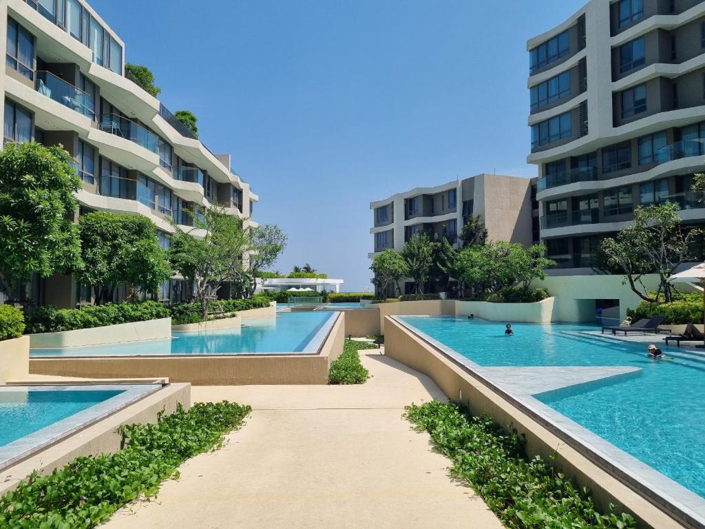una imagen de dos piscinas en un edificio en Veranda Residence Hua Hin 1BR Beachfront en Hua Hin