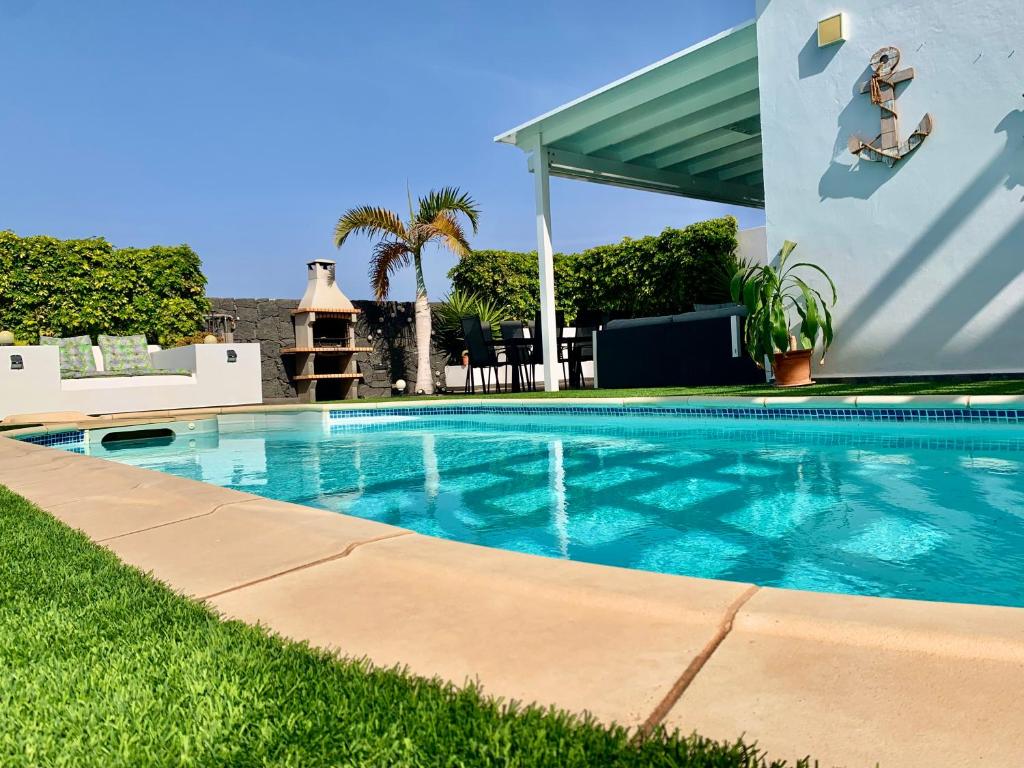 a swimming pool in front of a house at Villa Santa Maria in Costa Teguise
