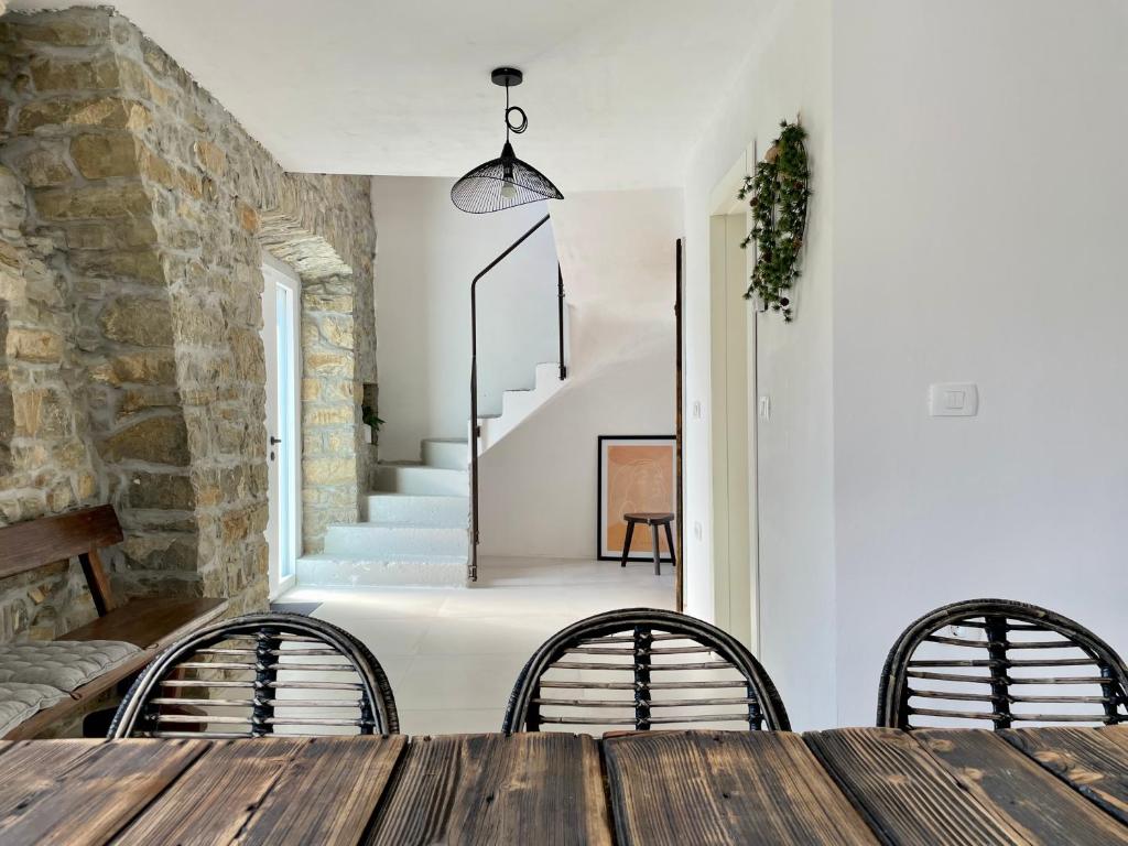 uma sala de jantar com mesa e cadeiras e uma parede de pedra em Apartment The Barn - Osp em Osp