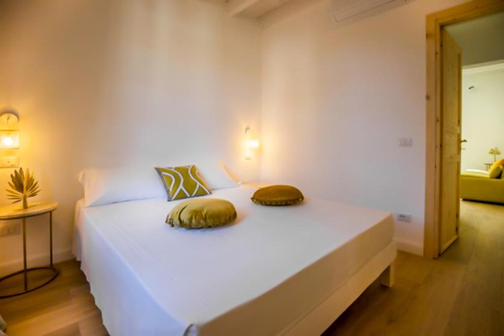 a bedroom with a white bed with two pillows on it at Maison d'Orange - La Pinede in Saint-Tropez