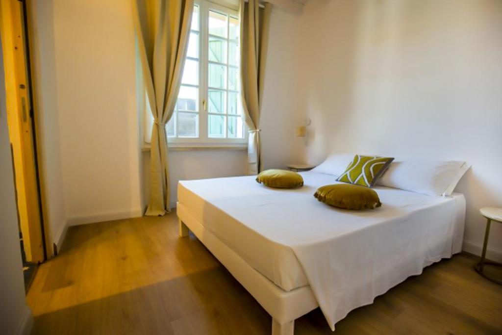 a bedroom with a white bed with two pillows on it at Maison d'Orange - La Pinede in Saint-Tropez