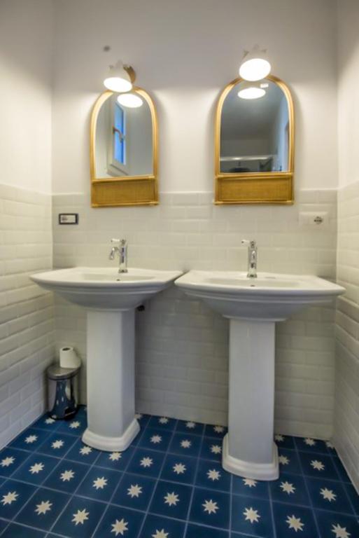 two sinks in a bathroom with two mirrors at Maison d'Orange - La Pinede in Saint-Tropez
