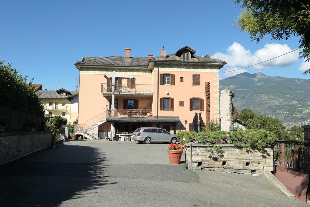 un gran edificio con un coche aparcado delante de él en Casa vacanze Valle d'Aosta - Maison Lugon, en Aosta