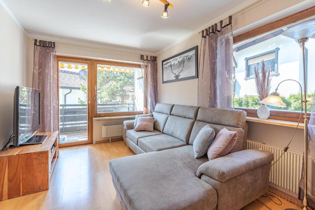 a living room with a couch and a tv at Breitenberg in Bad Hindelang