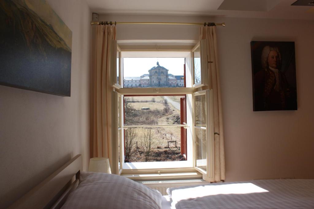 a bedroom with a window with a view of a building at Jeschkeho vila a Lázeňský dům in Kuks
