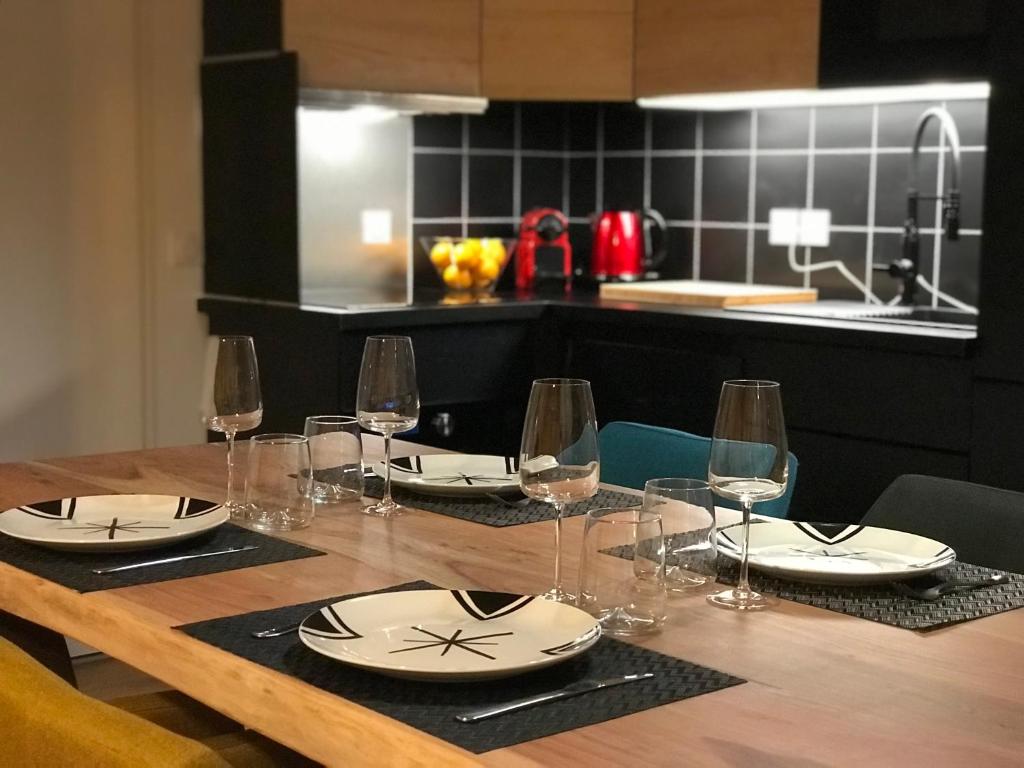 - une table en bois avec des assiettes et des verres à vin dans l'établissement Le chalet des étoiles, à La Mongie