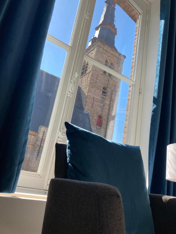 a window with a view of a clock tower at APL8 St-Anna B&B in Bruges