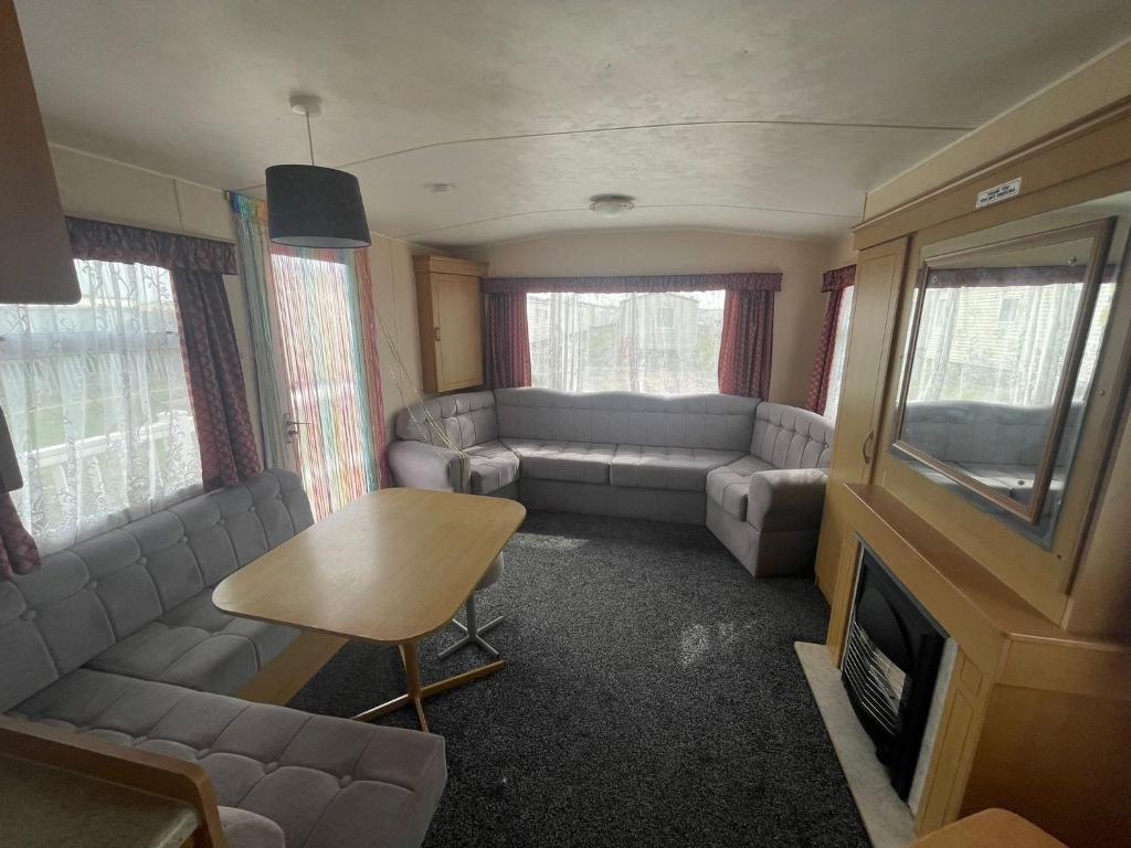 a living room with couches and a table and a tv at A13 THE CHASE 8 Berth Caravan in Skegness