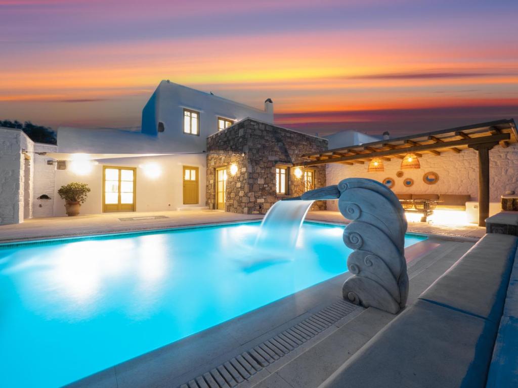 une piscine avec toboggan en face d'une maison dans l'établissement AG VILLAS, à Mykonos