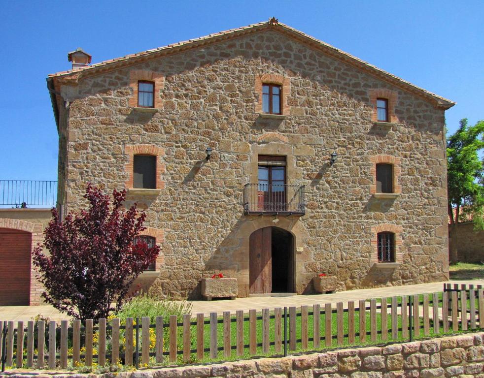 ein altes Steingebäude mit einem Zaun davor in der Unterkunft Casa Serra de Dalt in Lladurs