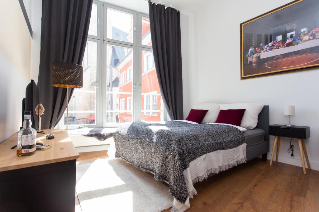 a bedroom with a bed and a large window at FULL HOUSE Apartment Hotel in Halle an der Saale