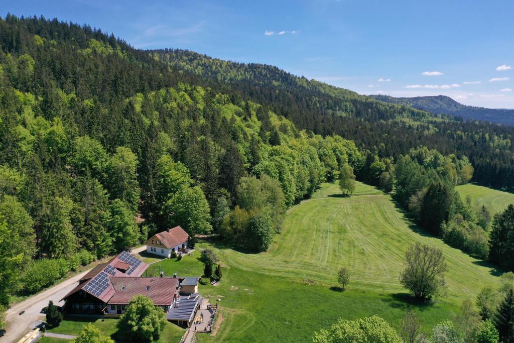 une vue aérienne d'une maison au milieu d'un champ dans l'établissement Altes Forsthaus Bodenmais, à Bodenmais
