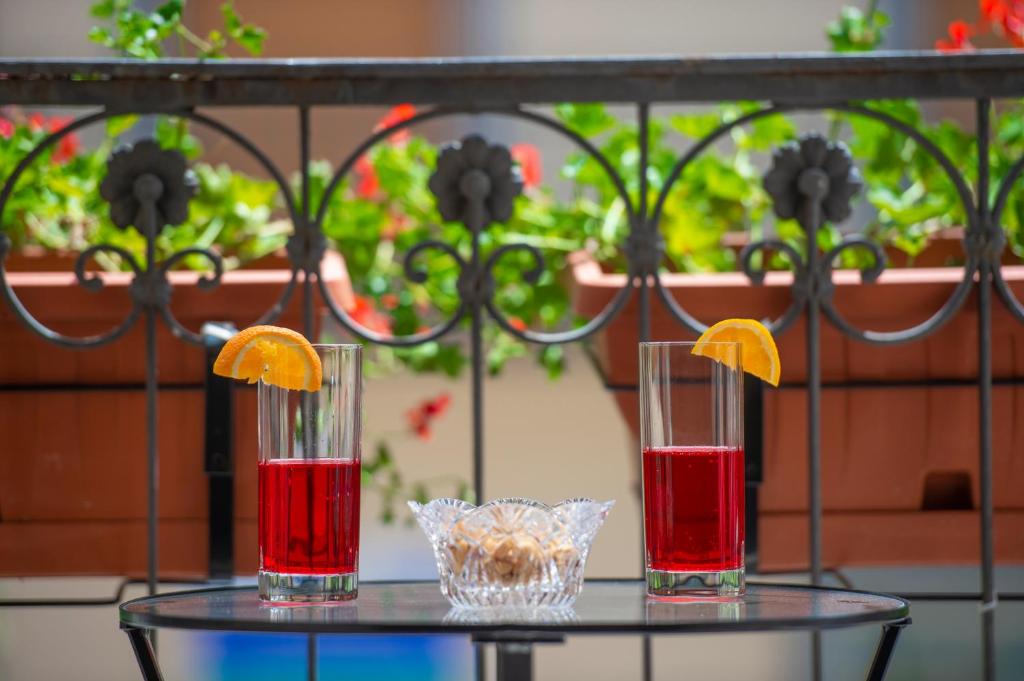 three cocktails on a glass table with oranges on top at Casa Villani in Agerola