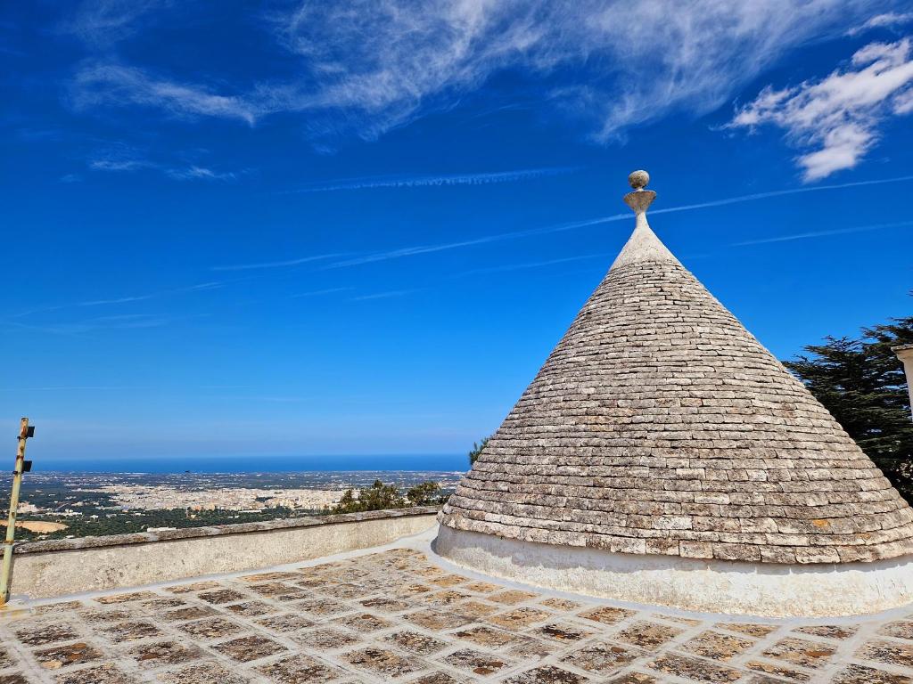 a pyramid top of a building with the ocean in the background at Villa Anna holiday house in Selva di Fasano