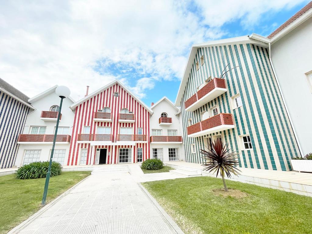 Une rangée de bâtiments avec un palmier dans la cour dans l'établissement CC - Casa da Costa, à Costa Nova