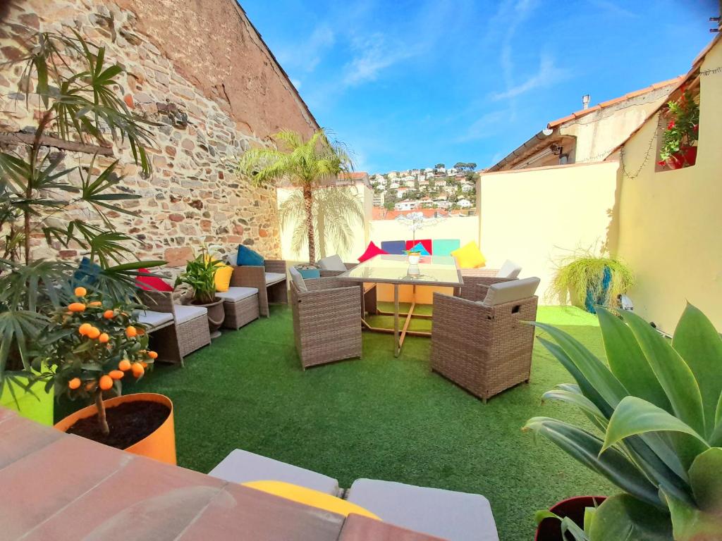 un patio extérieur avec une table, des chaises et des plantes dans l'établissement Appartement familial - 7pers- Hyères-centre, à Hyères