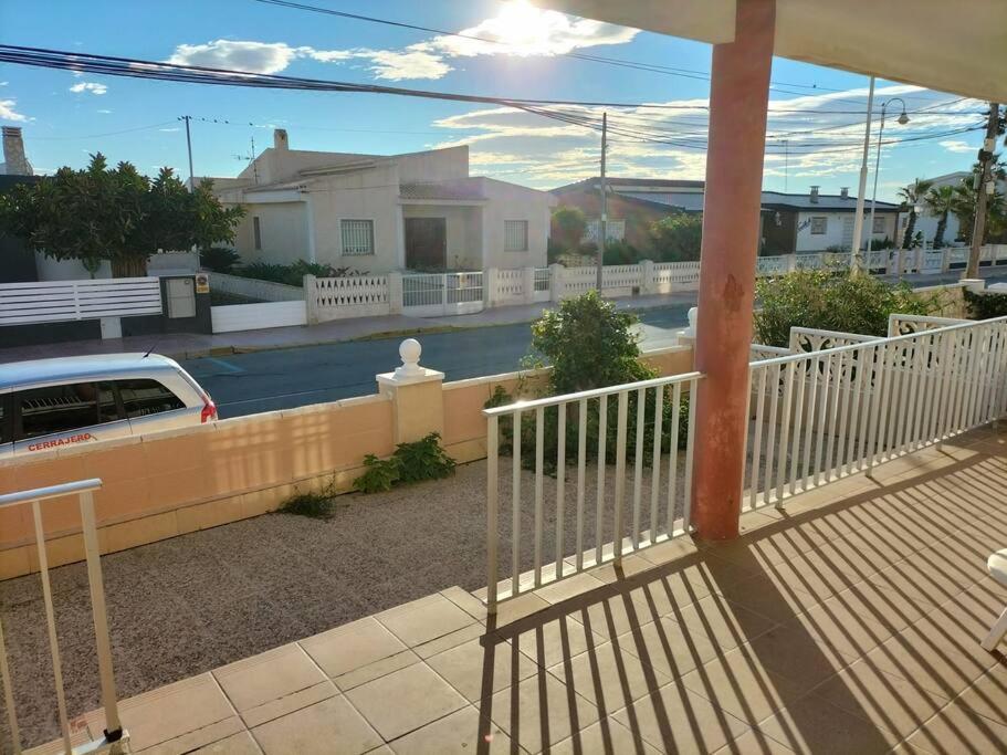 eine Veranda mit einem weißen Zaun und einem Haus in der Unterkunft Sol y Mar I in Guardamar del Segura