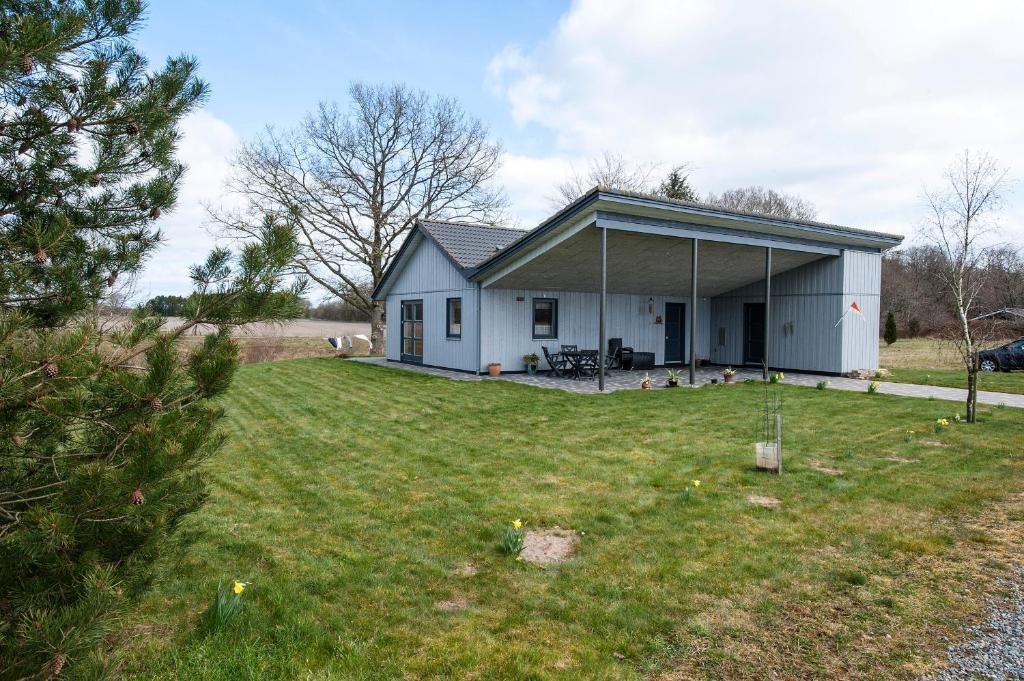 a small white house with a large yard at Hovborg Ferieby - Torpet 146 in Hovborg