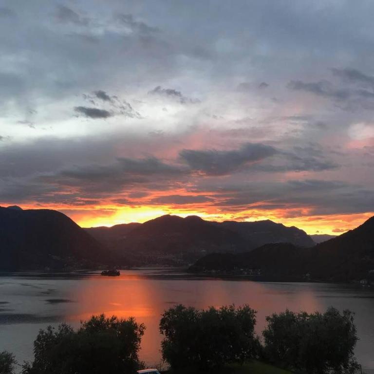 un coucher de soleil sur une grande étendue d'eau dans l'établissement Appartamento vista Lago d'Iseo, à Sulzano