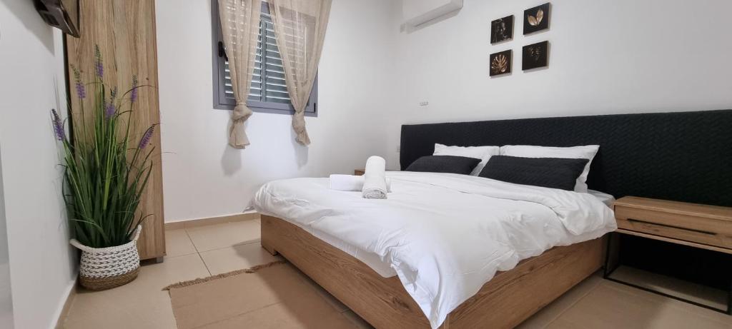 een slaapkamer met een bed met een zwart-wit dekbed bij Shoham apartment in Eilat