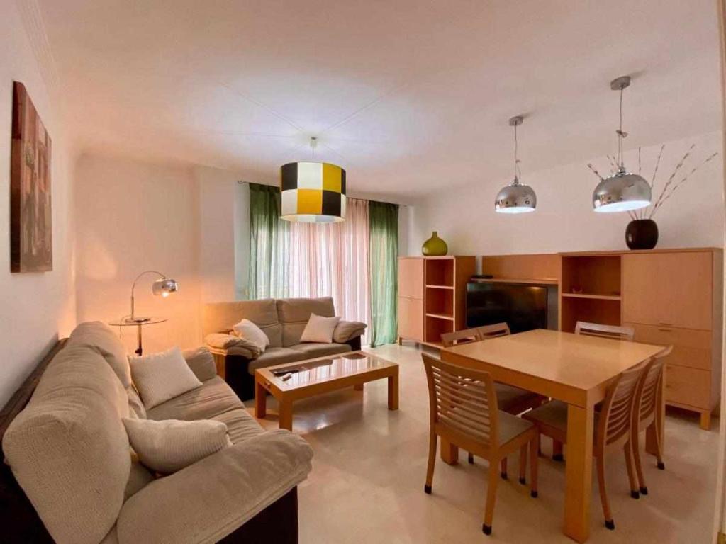 sala de estar con sofá y mesa en Chicflat Avenida España Ideal para familias en Estepona