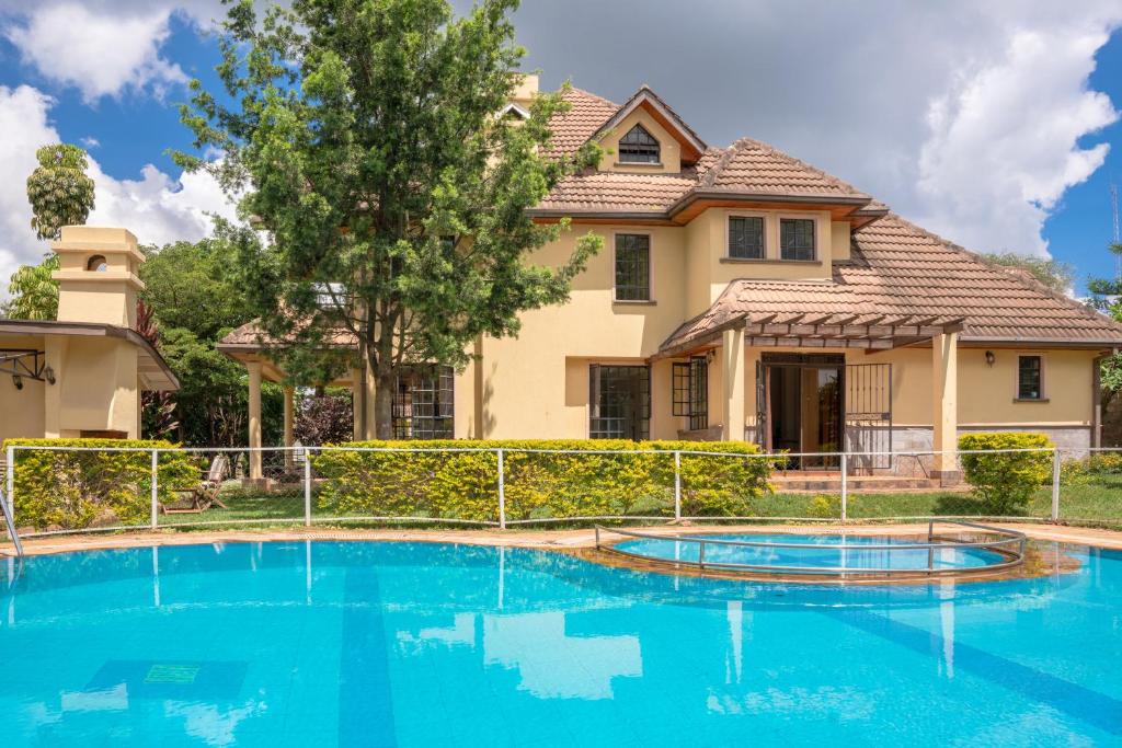 a house with a swimming pool in front of a house at dreamplace bed and breakfast Gigiri in Nairobi