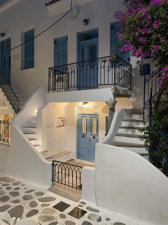 a white building with stairs and a blue door at BIANCO BLUE in Tinos Town