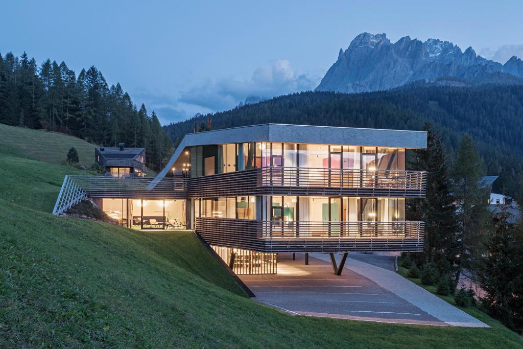a house on a hill with mountains in the background at Paramount Alma Suites in Sesto
