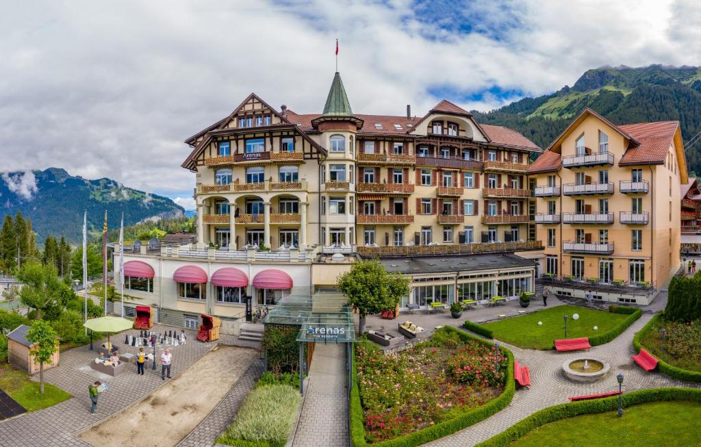 Hotel in Wengen in summer with Alpine facade and view of the village