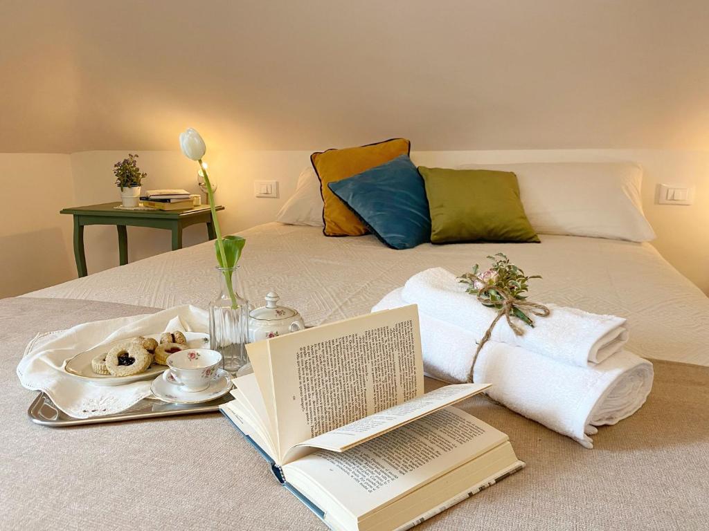 un letto con un vassoio di libri e un piatto di cibo di Casa Ginepro via Mazzini a Torino