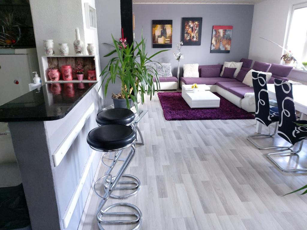 uma sala de estar com um sofá roxo e bancos em Holiday Home Livada em Ljubljana