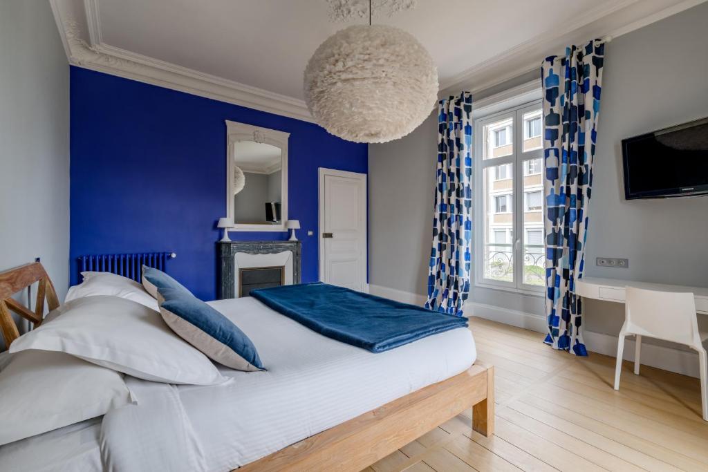 1 dormitorio con paredes azules y 1 cama con almohadas azules en Les Argentiers - Accès digitalisé, en Limoges