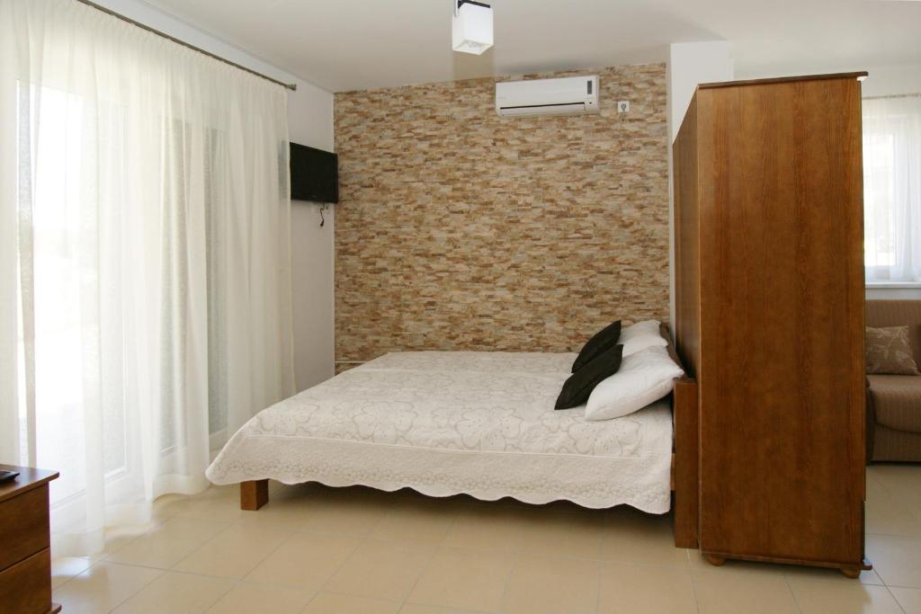 a bedroom with a bed and a brick wall at Villa Trio Srima in Srima