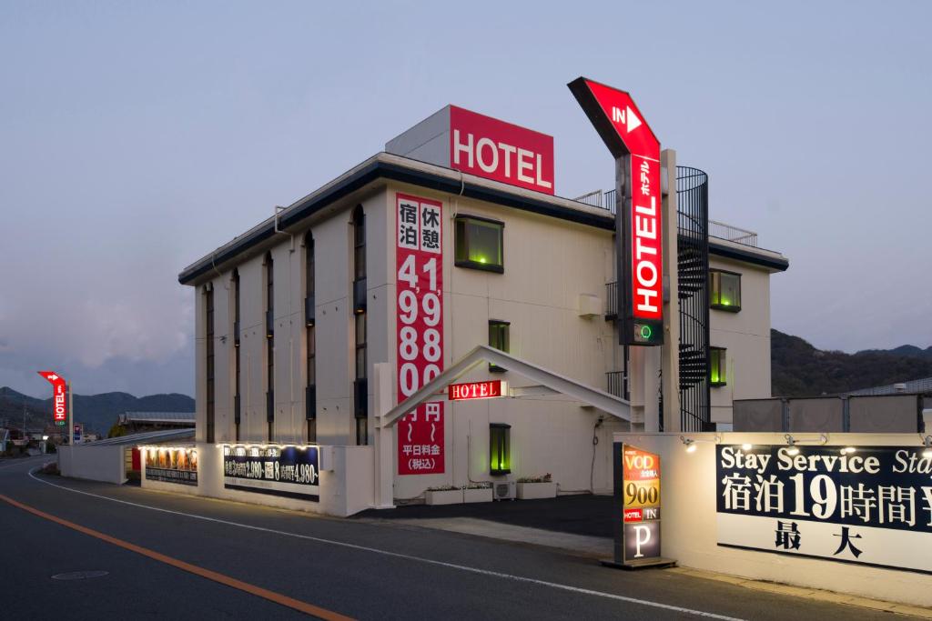 a hotel with signs on the side of a street at Hotel ニャンだふる in Himeji