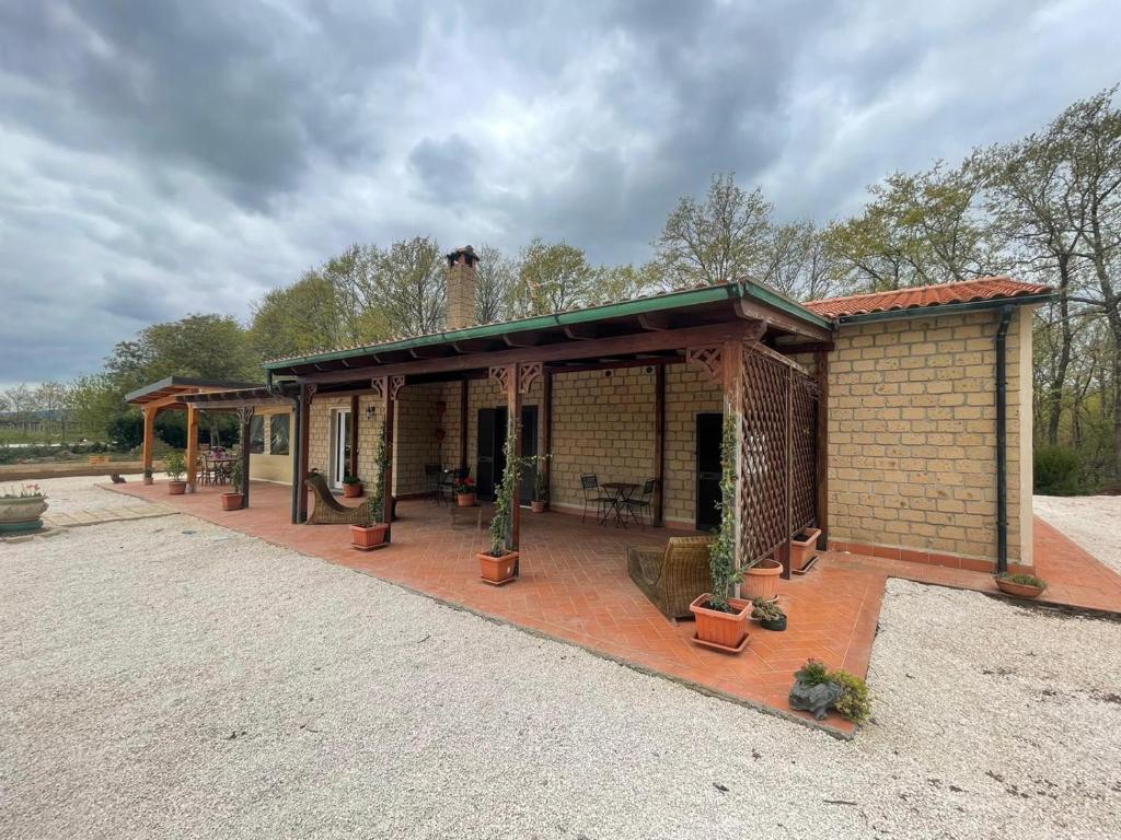 uma pequena casa com um pátio com vasos de plantas em Agriturismo Antiglia em Sovana