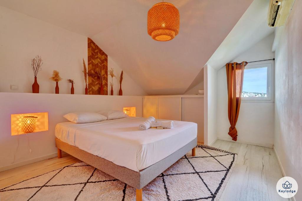 ein Schlafzimmer mit einem großen weißen Bett in einem Zimmer in der Unterkunft T4 - Le Romanéla 3 étoiles - 90 m2 - Saint Leu in Saint-Leu