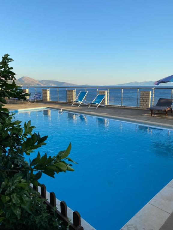 a large swimming pool with the ocean in the background at Ionian Bay Rooms in Qeparo